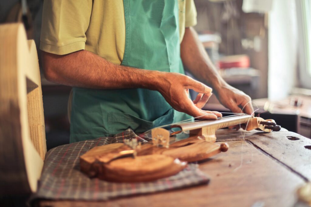 A luthier skillfully crafting a violin on a workbench in an artisan workshop.